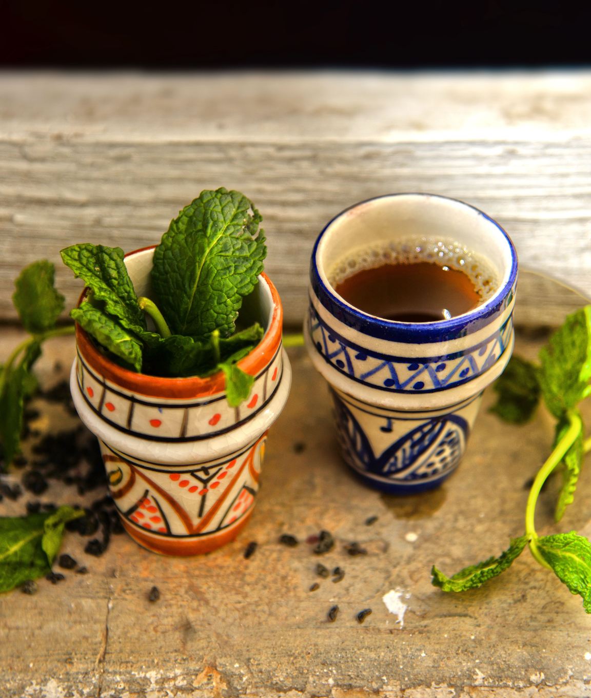 Two glasses of mint tea with fresh mint on a wooden table